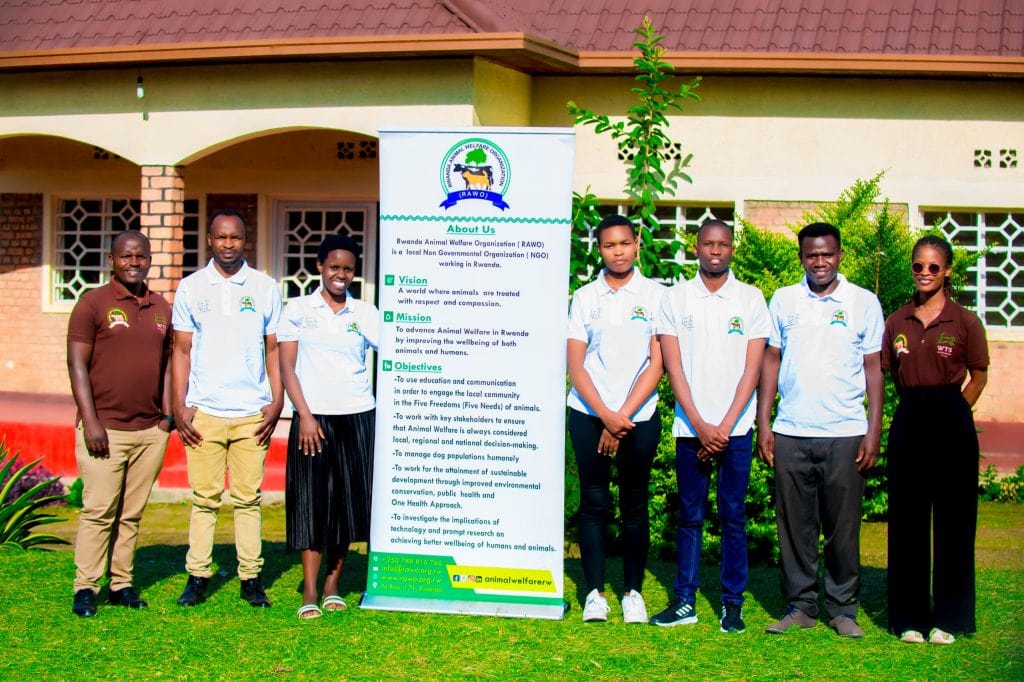 Two Montego Bay Animal Haven staff members sit inside van, one holding a dog.